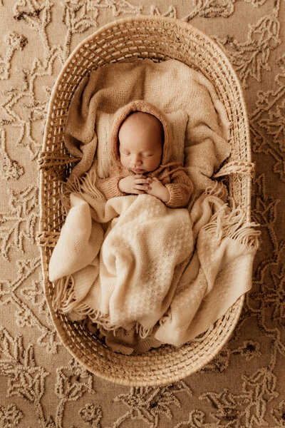 Baby boy sleeping in a Moses basket for a newborn photo session in OKC.