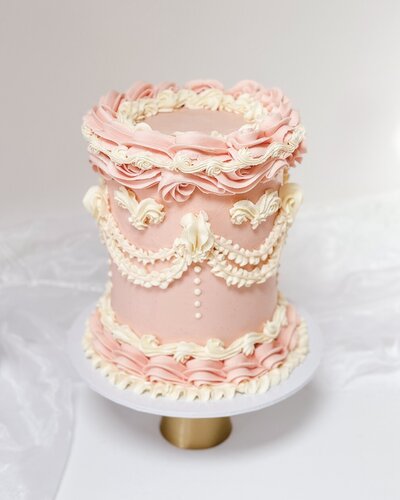 Vintage style Lambeth cake in pink and white buttercream in a Bridgerton cake style