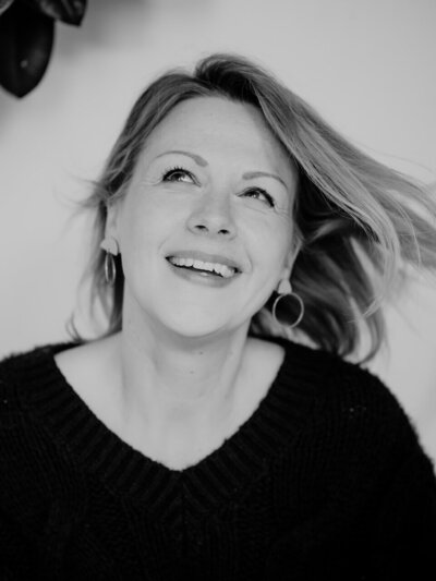 Boudoir-Aufnahme einer Frau mit sanftem Lächeln, intimes und ästhetisches Setting