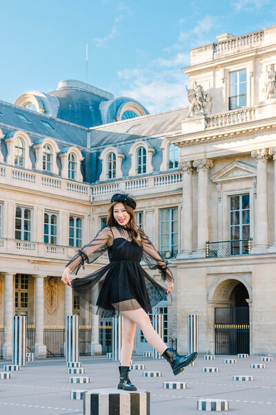 Stylish solo woman wearing a French beret, dress, and Doc Martens during a Paris photoshoot near the Eiffel Tower, Louvre, and Palais Royal.