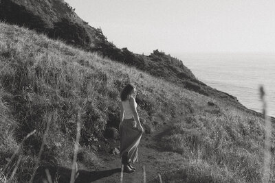 girl walking on beach with birds flying around her