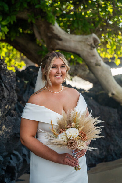 Bride smiling for elopement photos on the beach, by big island hawaii wedding photographer