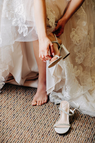 Wedding detail photo bridge putting on shoes