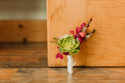 Detail wedding photo in Boone, NC of a corsage made of a succulent.