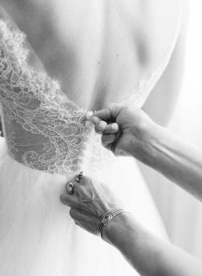 Bride getting zipped into her gown