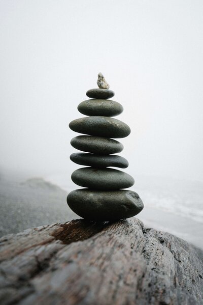 Stacked stones symbolizing balance and harmony, reflecting the supportive and collaborative nature of Wildseed Health’s group coaching sessions.