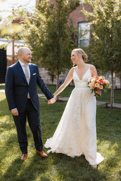 Couple walking together laughing outside of the Dogwood venue in The Grove