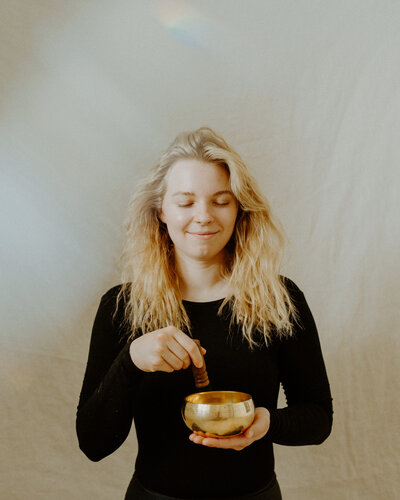 Woman smiling eyes closed while using a singing bowl