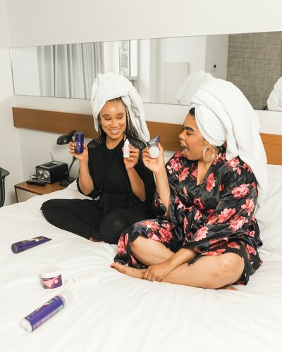 2 women relaxing on bed with towels and robes