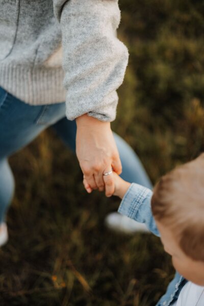 Mutter und Kind halten Händchen, fotografiert von oben