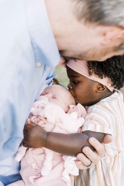 dad and daughter hugging newborn baby in outside peoria, illinois newborn photos 
