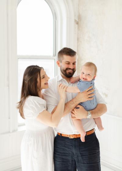 young couple holds their 6 month old baby during boston photoshoot