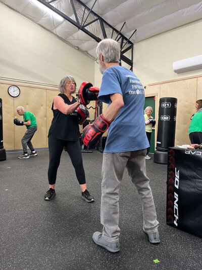 Lori and a man doing non-contact boxing in the Parkinson's exercise class in Eugene at the Warriors Gym. 