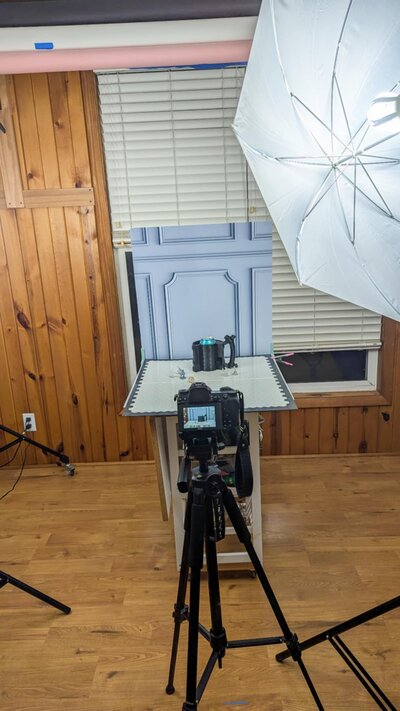 A plate of french macarons with a camera sitting on a white table