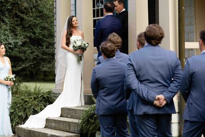 Bride holding dress while mom helps her put her wedding dress wrap on