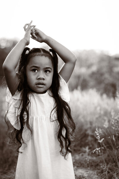 Daughter holding her hands up in black and white photograph
