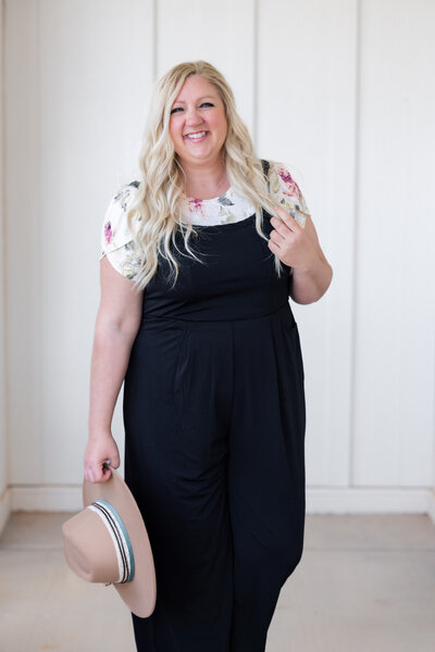 woman in black overalls smiling at camera