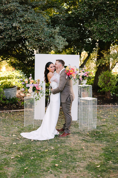Groom kissing bride on her cheek