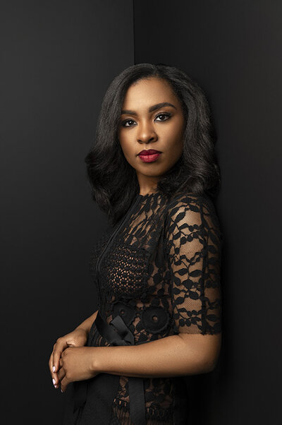 Woman in orange dress poses in photography studio in northern virginia