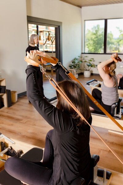 student-reformer-straps-classical-pilates-class