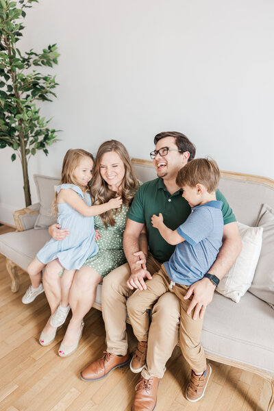 a family posing for portraits on a sofa