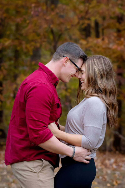 A couple leaning their foreheads together and laughing during their Northern Virginia family photo session.