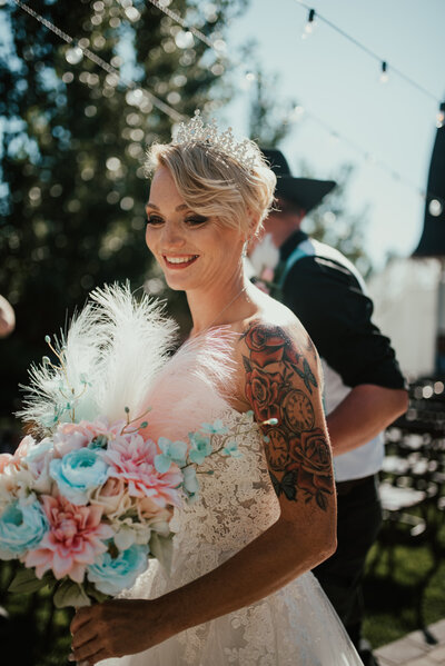 beautiful tatted woman walking down the isle at her Utah wedding
