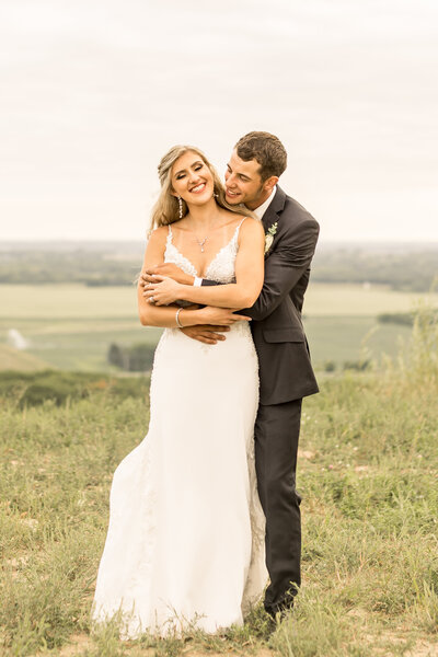 Groom hugging bride during wedding photos