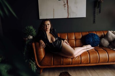 Darkly lit boudori portrait of woman posing in a room with glamour styling