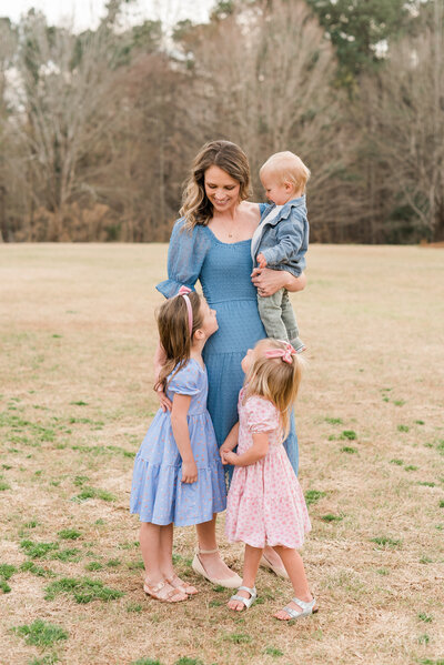 Mom holds and laughs with her 3 kids during a Raleigh Family Photographer session. Photographed by Raleigh Family Photographer A.J. Dunlap Photography.