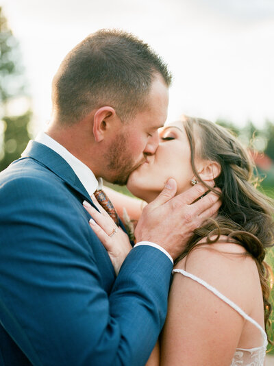 bride and groom kiss under a chandalier in front of the lairmont manor in bellingham washington