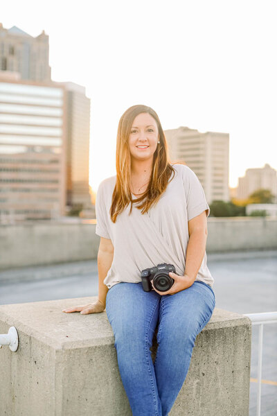 Elizabeth smiles while holding a camera