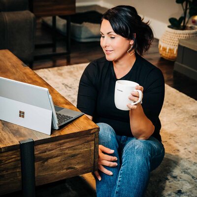 Missoula realtor working on laptop holding a cup of coffee