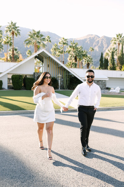couple walking happily with palm trees behind them