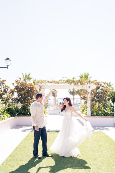 Groom twirling his bride at their wedding at the Hotel Del Coronado