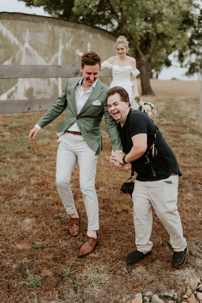 Videographer helps groom walk down a hill