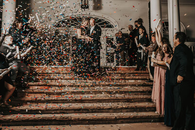 newlyweds walk down stairs with confetti