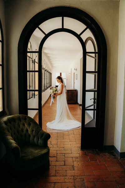 bride standing in a hallway holding her bridal bouquet