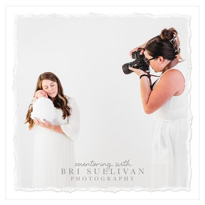 In this picture, a mom and her baby are posing for a photographer during a mentoring session led by photographer Bri Sullivan. The mom is gently holding the baby, who is wearing an all white wrap. The photographer has captured the natural interaction between mother and child, showcasing their connection and love for one another.