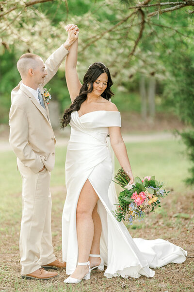 Bride and groom take a romantic walk through a lush garden in spring, surrounded by vibrant flowers and fresh greenery, embracing the beauty of their wedding day.