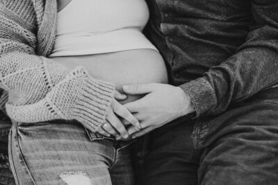 Black and white image of couple touching pregnant belly photographed by Oregon maternity photographer.