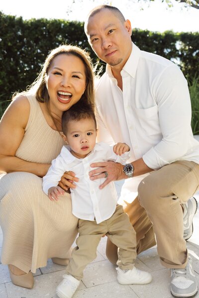 Bay Area Lifestyle Photographer - Ellobelle Photography Family Photographer crouched with husband and toddler in coordinated neutral outfits