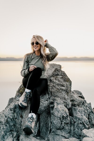 girl smiling sitting on a rock