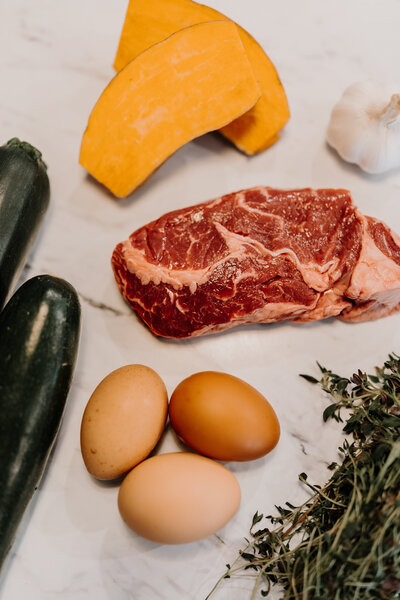 Eggs on the counter next to herbs and meat