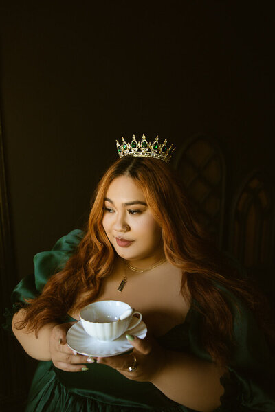 woman in crown holding a tea cup
