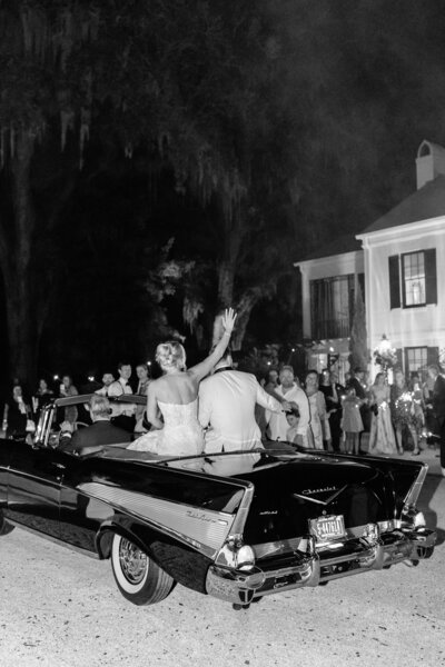candid black and white photo of bride & groom entering their reception