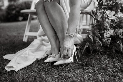 bride putting on her bridal shoes