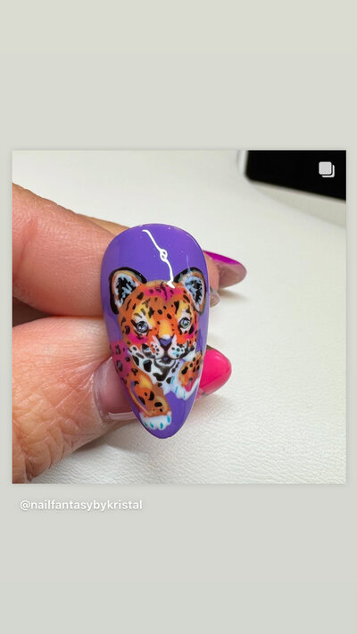 Detailed tiger painted on a purple nail done by Kristal