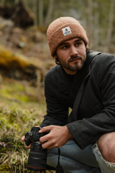 Guy kneeling in the Dolomites with camera in hand