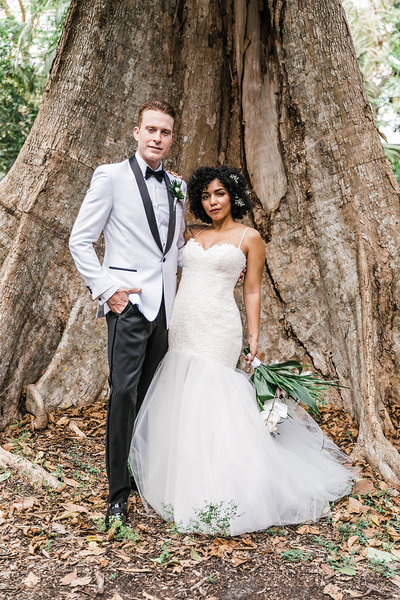 bride & groom standing in front of tree
